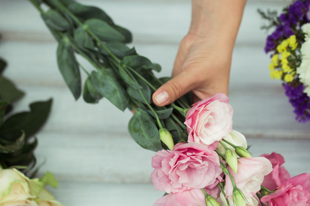 Female florist making beautiful bouquet at flower shopの写真素材