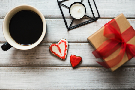 Box with a present to the Valentine's Day cookies in the shape of a heart and cups of black coffeeの写真素材