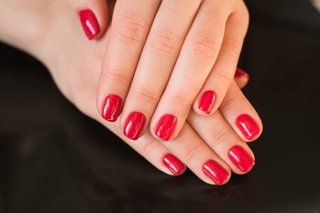 red manicure with nail on a black backgroundの写真素材