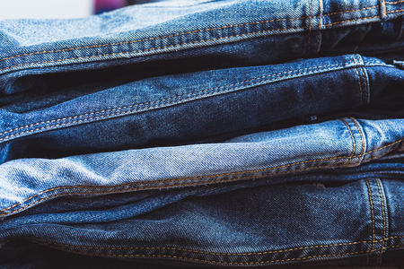 Jeans stacked on a wooden backgroundの写真素材