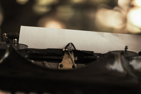 Old black typewriter with paper worth on the tableの写真素材