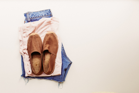 Ideal clothes for summer outfits: a shirt, jeans, shoes. View from above.の写真素材