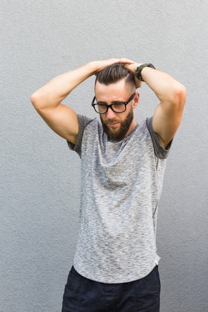 Man with beard holding his head. Isolated on grey background.の写真素材