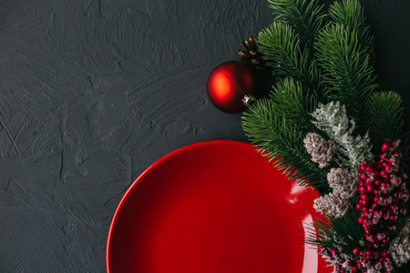 Christmas table with red plate and spruce and bullets. New Year's holiday backgroundの写真素材