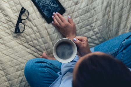 Cute girl with a beautiful manicure drinking coffeeの写真素材