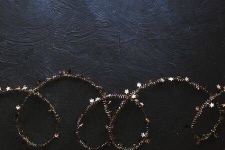 Christmas golden garland with stars on a black background.の写真素材