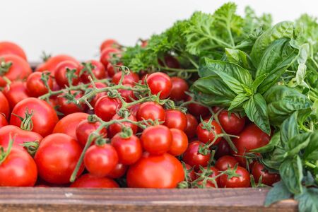 Cherry tomatoes in old wooden tray.の写真素材