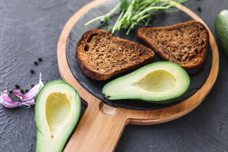 Detox breakfast. Freshly cooked whole grain toasts with avocado spread and microgreen sprouts, close upの写真素材
