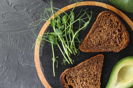 Detox breakfast. Freshly cooked whole grain toasts with avocado spread and microgreen sprouts, close upの写真素材
