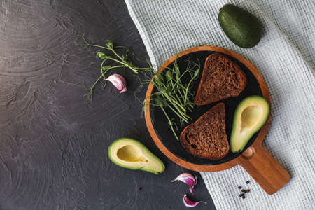 Detox breakfast. Freshly cooked whole grain toasts with avocado spread and microgreen sprouts, close...
