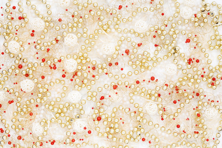 Creative chaos of Christmas decoration. Gold pearl beads, garland lights and ornaments on white. Flat lay. Winter holiday abstract  backgroundの写真素材