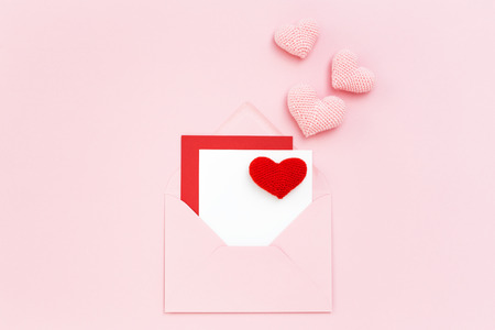 Valentine card in pink envelope with red & pink hearts. Minimal style greeting card. Birthday, Mothers day, Women's Day. Love letter. Copy space, flat lay.の写真素材