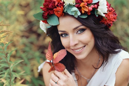autumn portrait of romantic woman with flowers in her hair in a wreathの写真素材