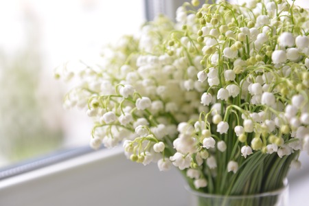 flowers lily of the valley stand on the table backgroundの写真素材