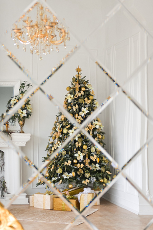 Christmas decor in studio of a classic style living room with a vintage armchair, fireplace, Christmas tree. New Years interiorの写真素材