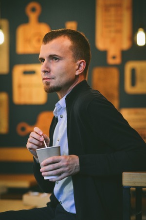 Portrait man drink coffee sitting in cafe.の写真素材