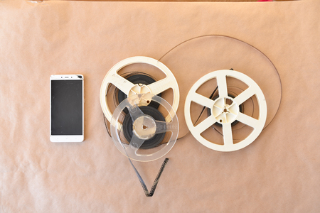 Old vintage cinematic reels with a video film lie on the background of the Kraft surface. Top view. broken phoneの写真素材