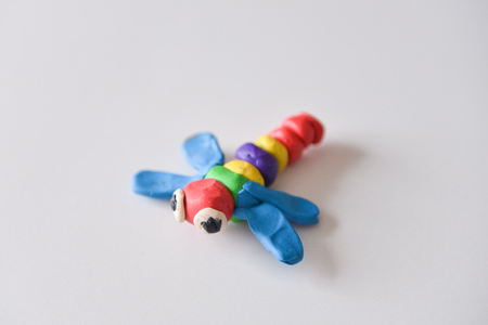 baby playing and learning with plastilin. development of fine motor skills, childrens sculpture dragonfly insectの写真素材