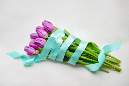 tulips blue ribbon on an isolated white background festive bouquet for the birthday, March 8, baby shower, mothers day, womens day. floristic compositionの写真素材