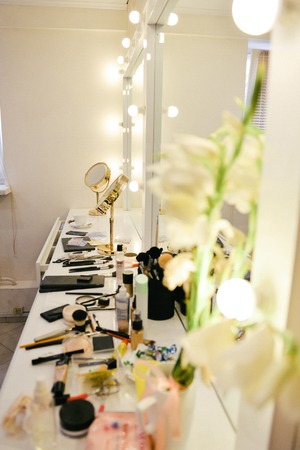closet room with make-up vanity table, mirror and cosmetics product in flat style house.