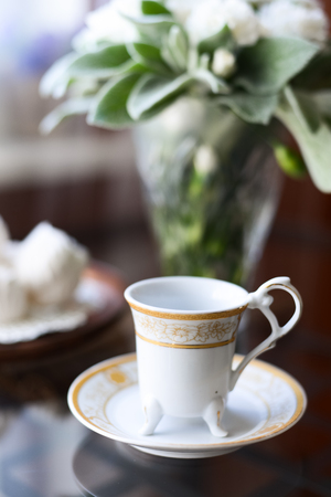 coffee with an airy white marshmallow dessert a bunch of fresh flowers on the tableの写真素材