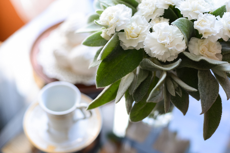 coffee with an airy white marshmallow dessert a bunch of fresh flowers on the tableの写真素材