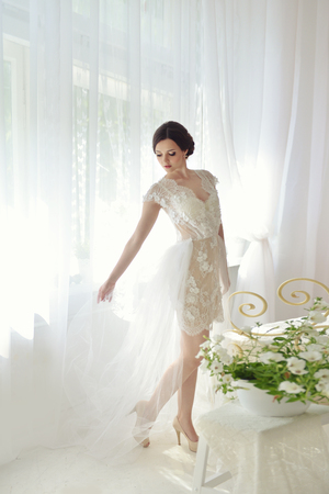 Young attractive female model girl before the wedding. Morning boudoir of the bride. Beautiful lingerie and dress, delicate imageの写真素材