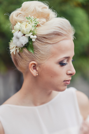 wedding hairstyle for the bride blond blonde hair with accessories hairpins from fresh flowersの写真素材