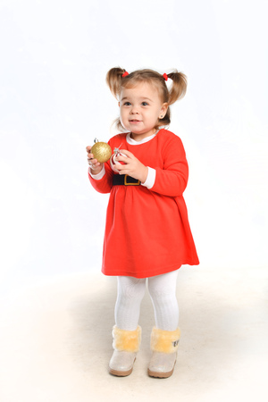 surprised emotional kid girl in santa costume posing on white isolated background in new year holidayの写真素材