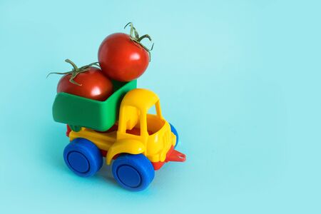 tomatoes natural vitamins are in the back of truck in a childrens toy car food delivery truck logisticsの写真素材