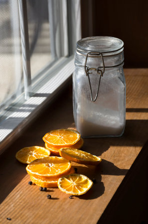 Dried sliced oranges, glass jar with sugar inside, day light shot.の写真素材