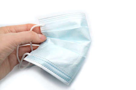 Woman hands holding medical mask, close up on white background. Coronavirus or covid-19 protection...