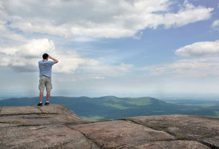 View of Adirondack High Peaks from Prospect Mountain. Man looking at the sky and mountains.