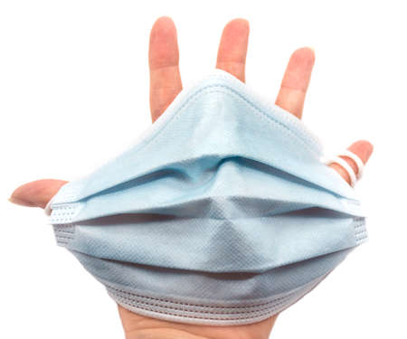 hand holding medical mask, close up on white background. Coronavirus or covid-19 protection item,...
