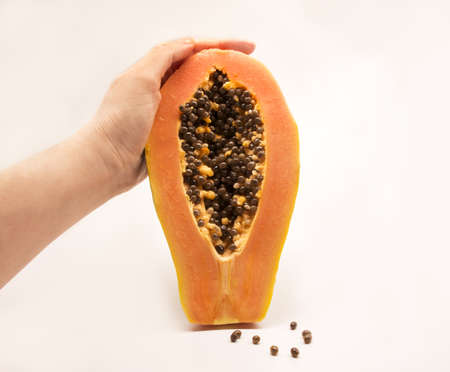 hand holding fresh ripe papaya fruit with seeds isolated on white background.の写真素材