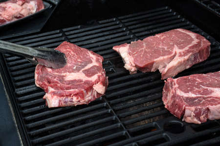 Grilling fresh meat. Grilling steaks on flaming grill