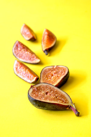 figs on yellow background. Fresh purple fig fruitの写真素材