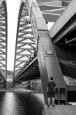 Man standing under bridge looking forward into distance. The Thaddeus Kosciusko Bridge in Albany NY.の写真素材