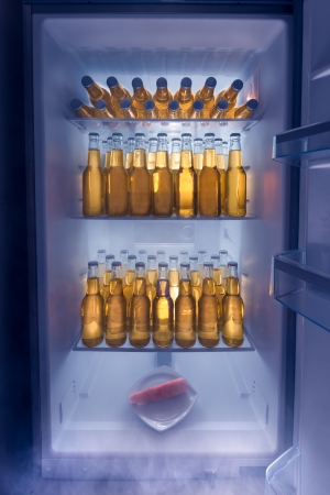 Fridge full of cold beer with one lonely carrotの写真素材