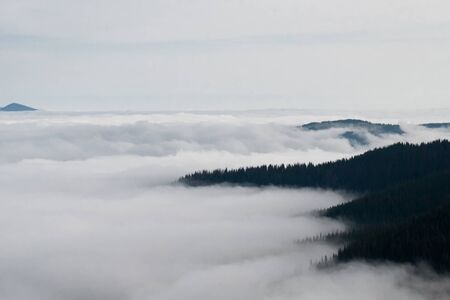 Mountain landscape of the ridge covered by cloudsの写真素材