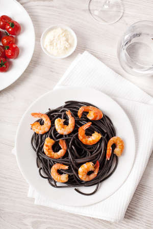 Black italian pasta with shrimps food on light backgroundの写真素材
