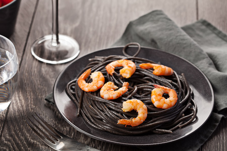 Black italian pasta with shrimps food on dark backgroundの写真素材