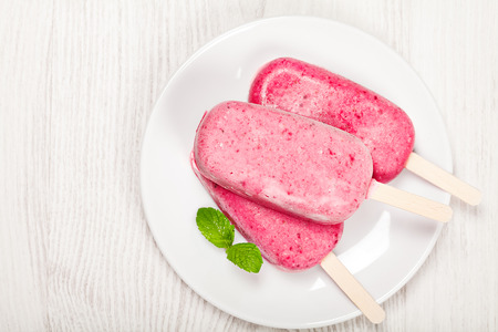Strawberry popslice icecream on light wooden backgroundの写真素材