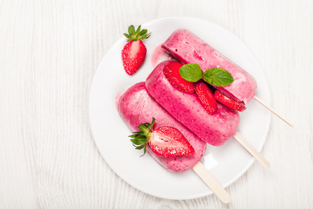 Strawberry popslice icecream on light wooden backgroundの写真素材