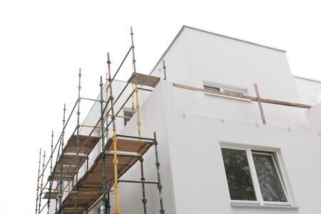 scaffolding on building house wall, on construction site isolatedの写真素材