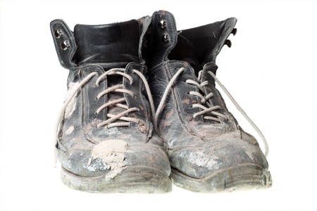 Black Worn-out old work boots, isolated on white. の写真素材