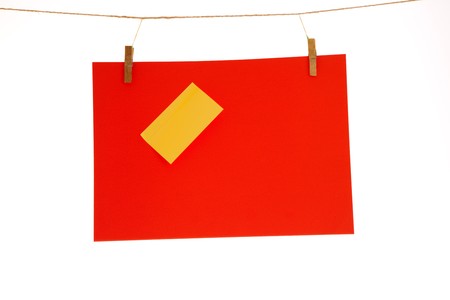 Red paper sheet and yellow on a clothes line. Isolated on white background. の写真素材