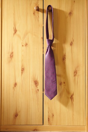 red Striped Necktie hung from a hook wardrobe