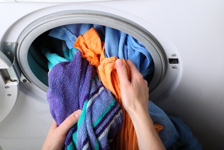 woman loading Preparation washing machine in bathroom clothes in the washing machineの写真素材