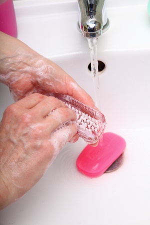 Woman wash red soapy hands in bathroom soap nail brush person scrubbing nailsの写真素材